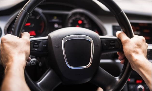 Image of two hands on a car steering wheel